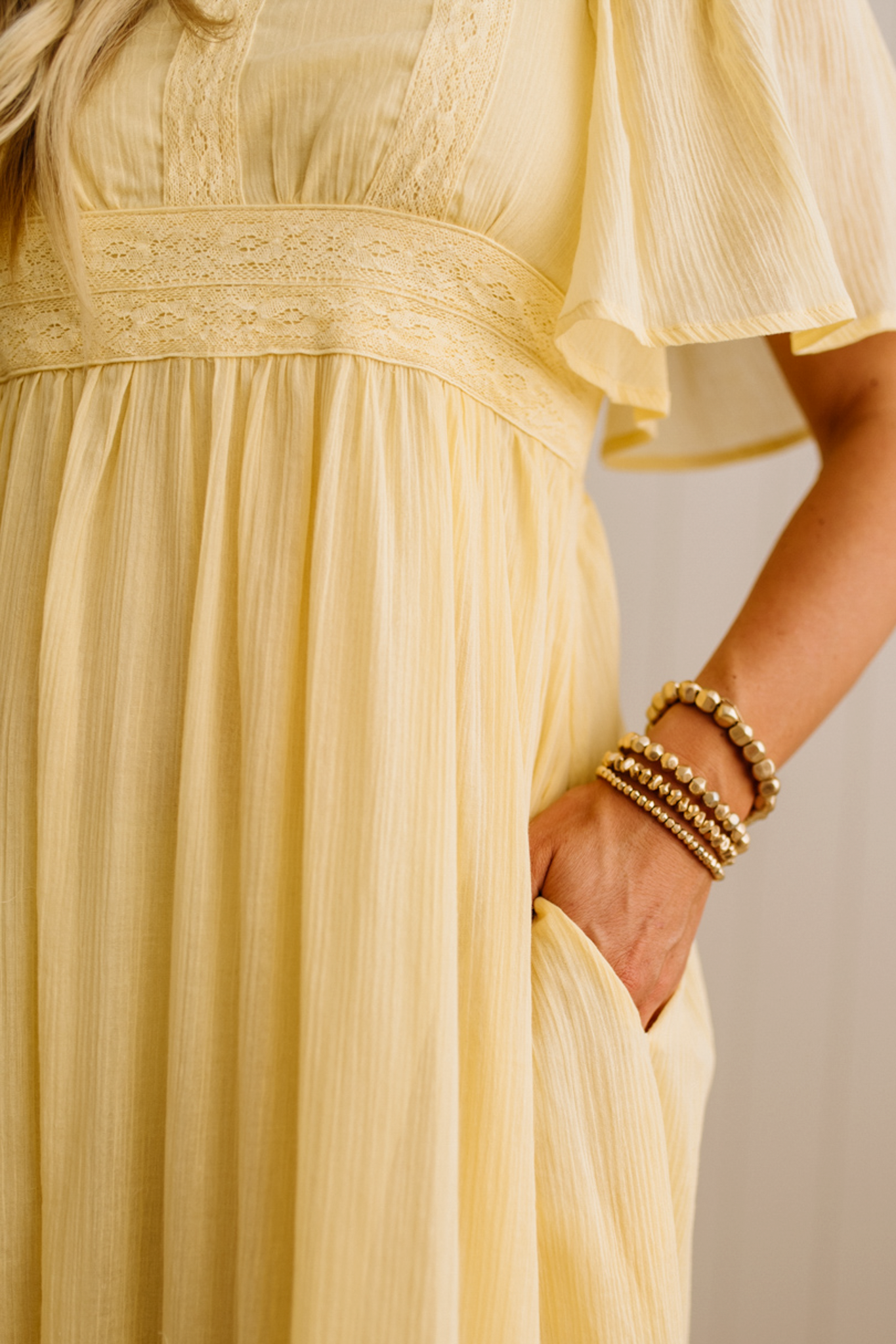 Blonde Woman Wearing a Lemon Yellow Lace Inset Flutter Sleeve Maxi Dress