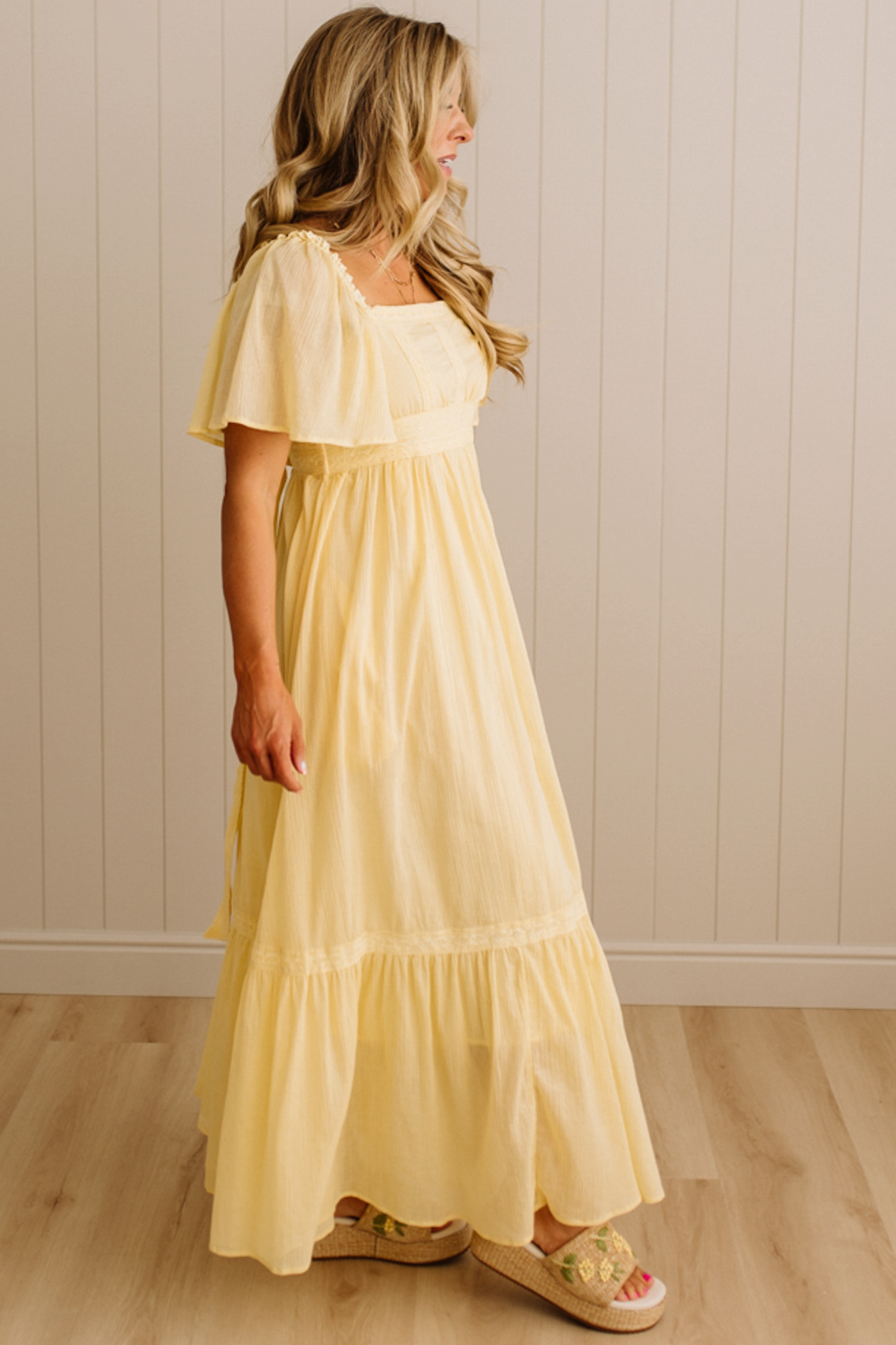 Blonde Woman Wearing a Lemon Yellow Lace Inset Flutter Sleeve Maxi Dress