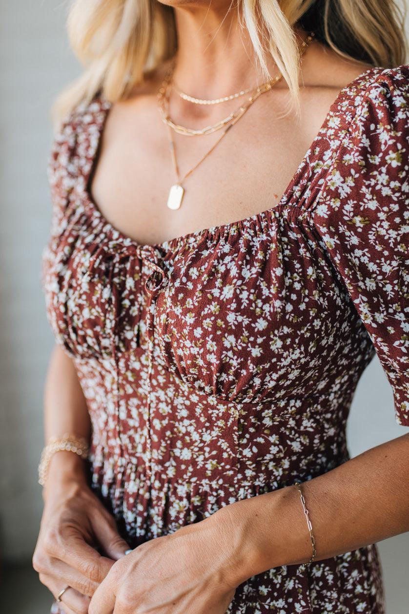 Woman wearing a floral dress with a neutral background