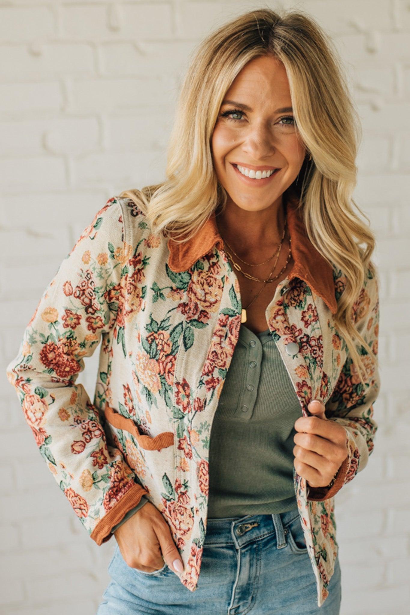 Woman wearing a floral jacket with a white brick wall background