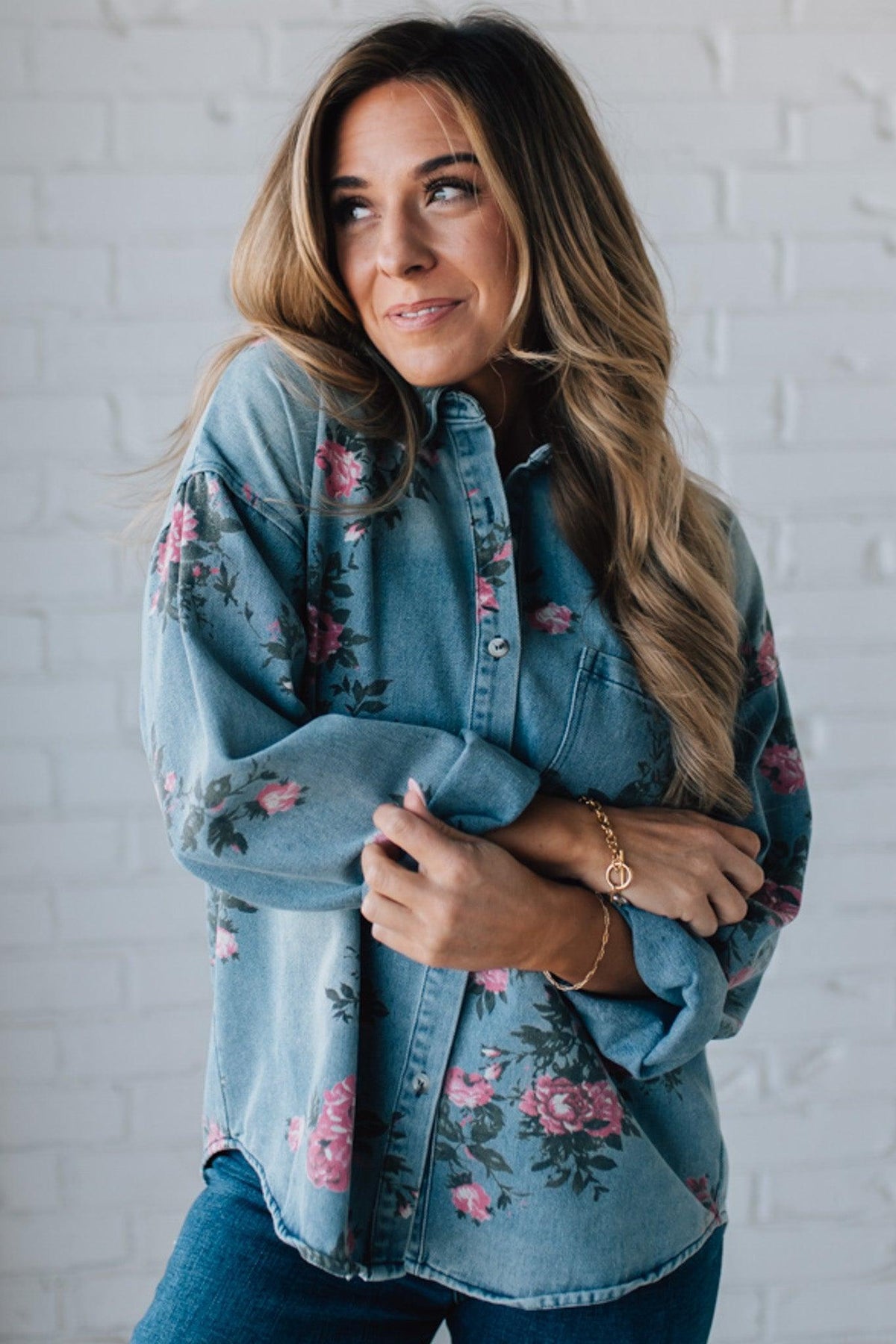 blonde girl modeling a long sleeve button front denim top with pink floral pattern