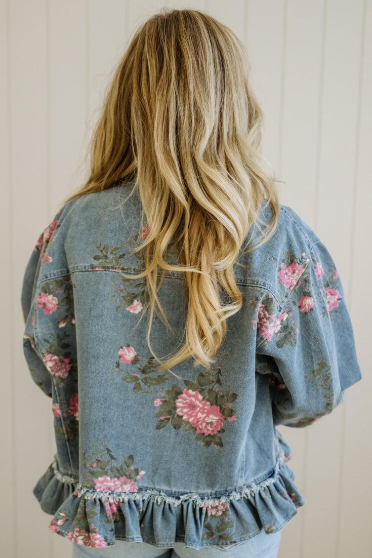 Denim jacket with floral embroidery on a plain background