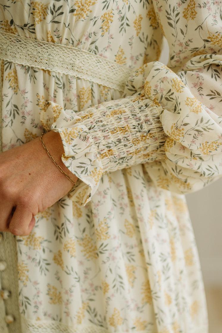 Close-up of a person wearing a floral dress with a neutral background