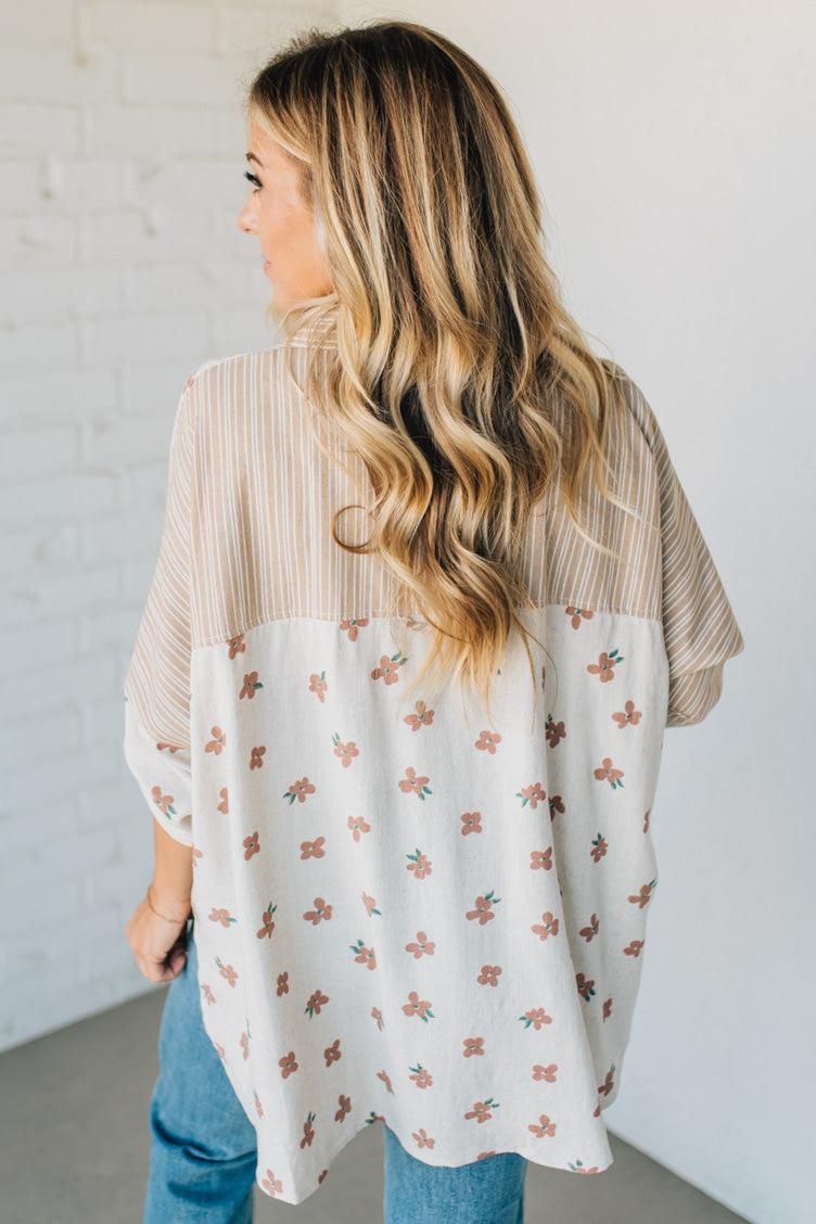 Woman wearing a floral blouse with a plain background
