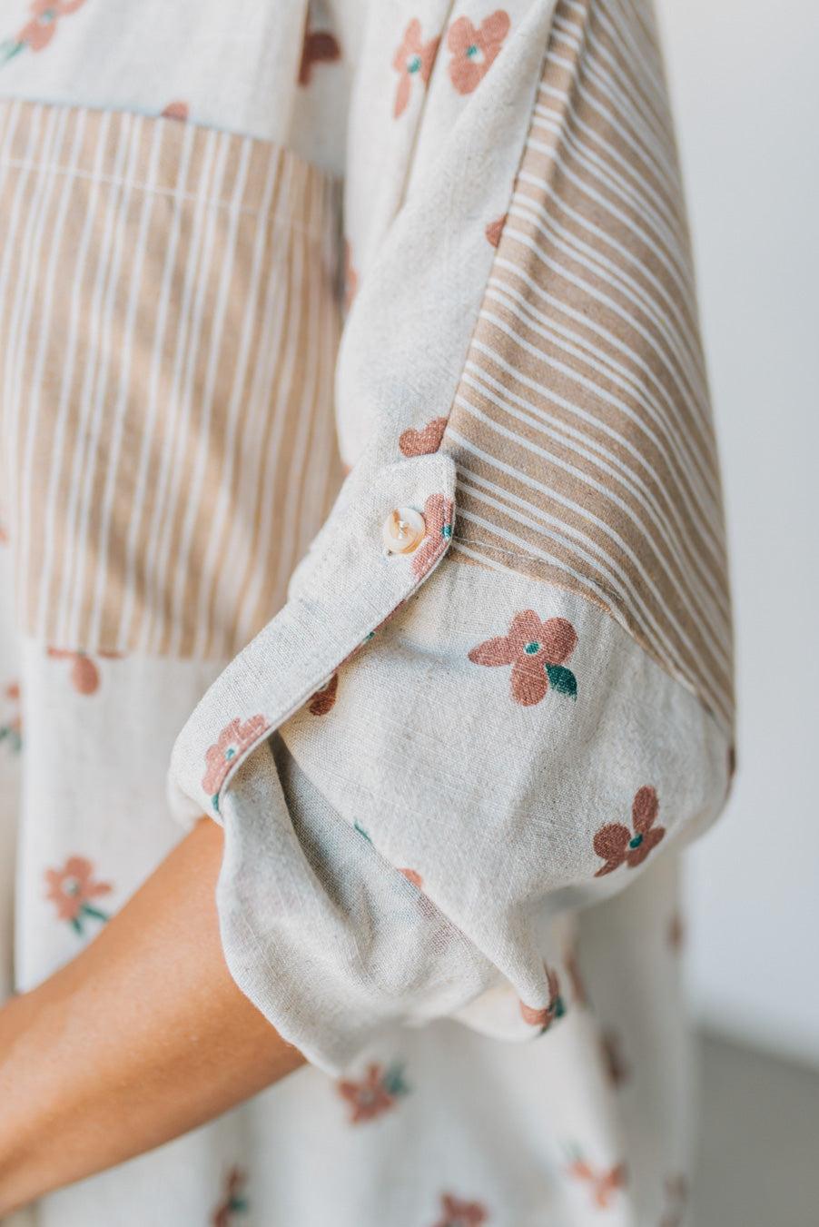 Close-up of a baby outfit with floral embroidery on a plain background