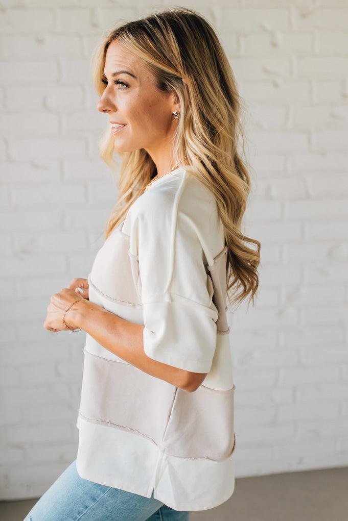 Woman wearing a white blouse with a neutral background
