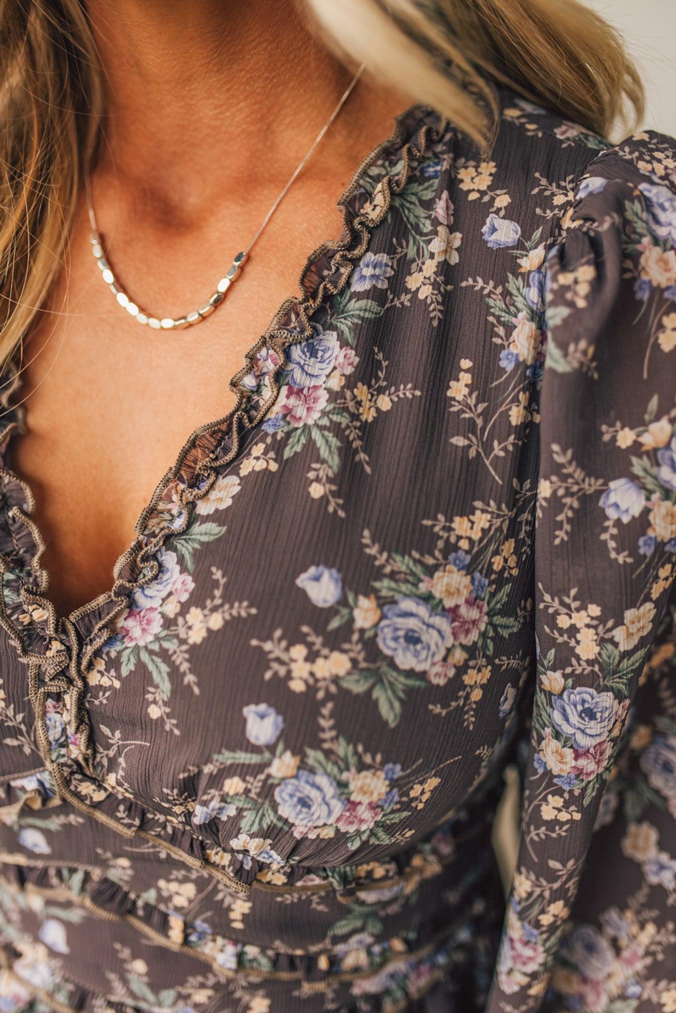 Floral patterned dress with a necklace worn by a person