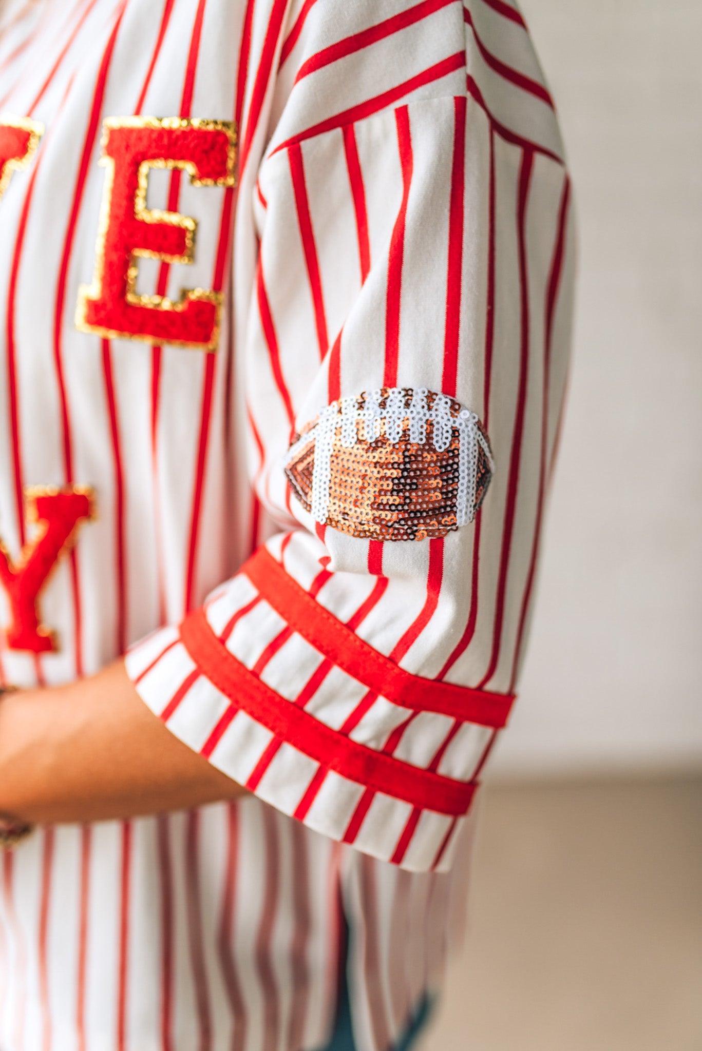 Close-up of a person wearing a red and white striped shirt with a decorative arm sleeve.
