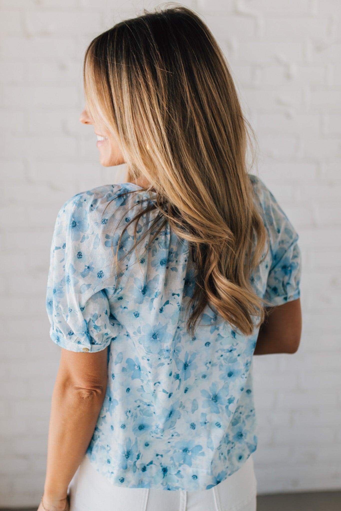 BLONDE WOMAN WEARING A FLORAL BOXY PUFF SLEEVE BUTTON UP TOP