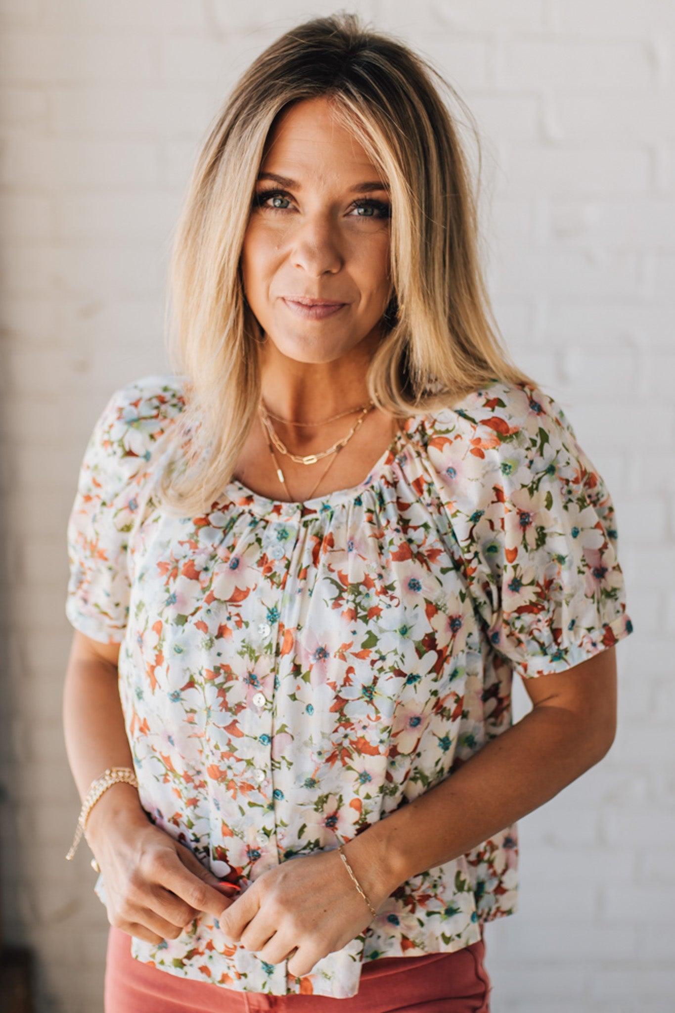 BLONDE WOMAN WEARING A FLORAL BOXY PUFF SLEEVE BUTTON UP TOP