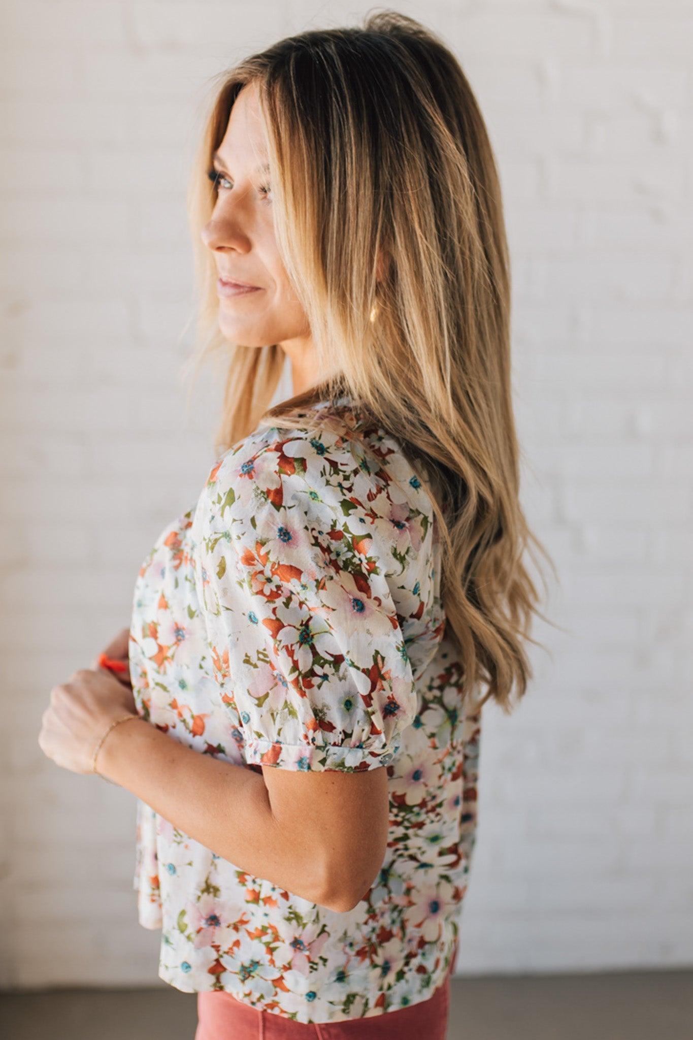 BLONDE WOMAN WEARING A FLORAL BOXY PUFF SLEEVE BUTTON UP TOP