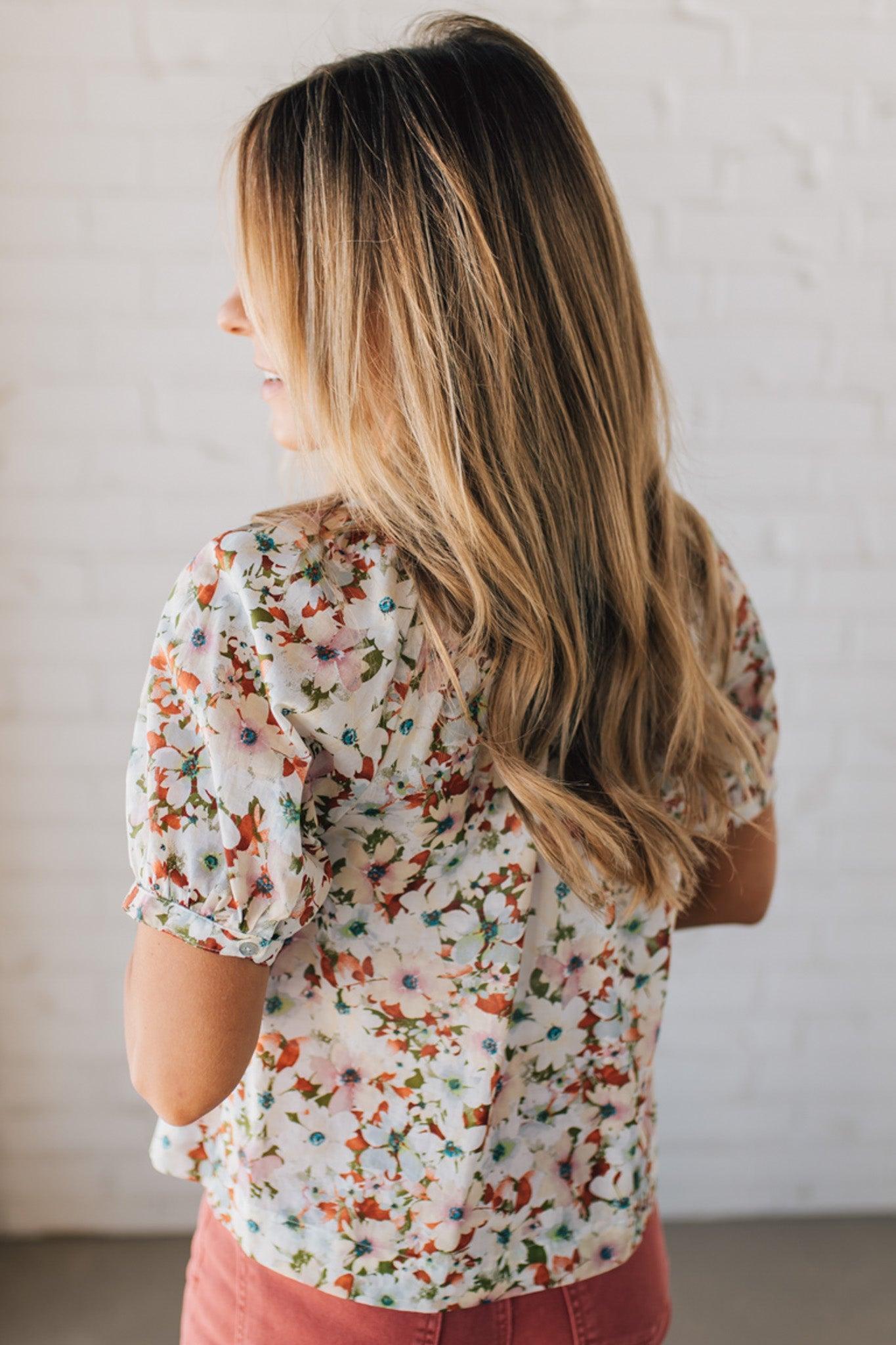 BLONDE WOMAN WEARING A FLORAL BOXY PUFF SLEEVE BUTTON UP TOP