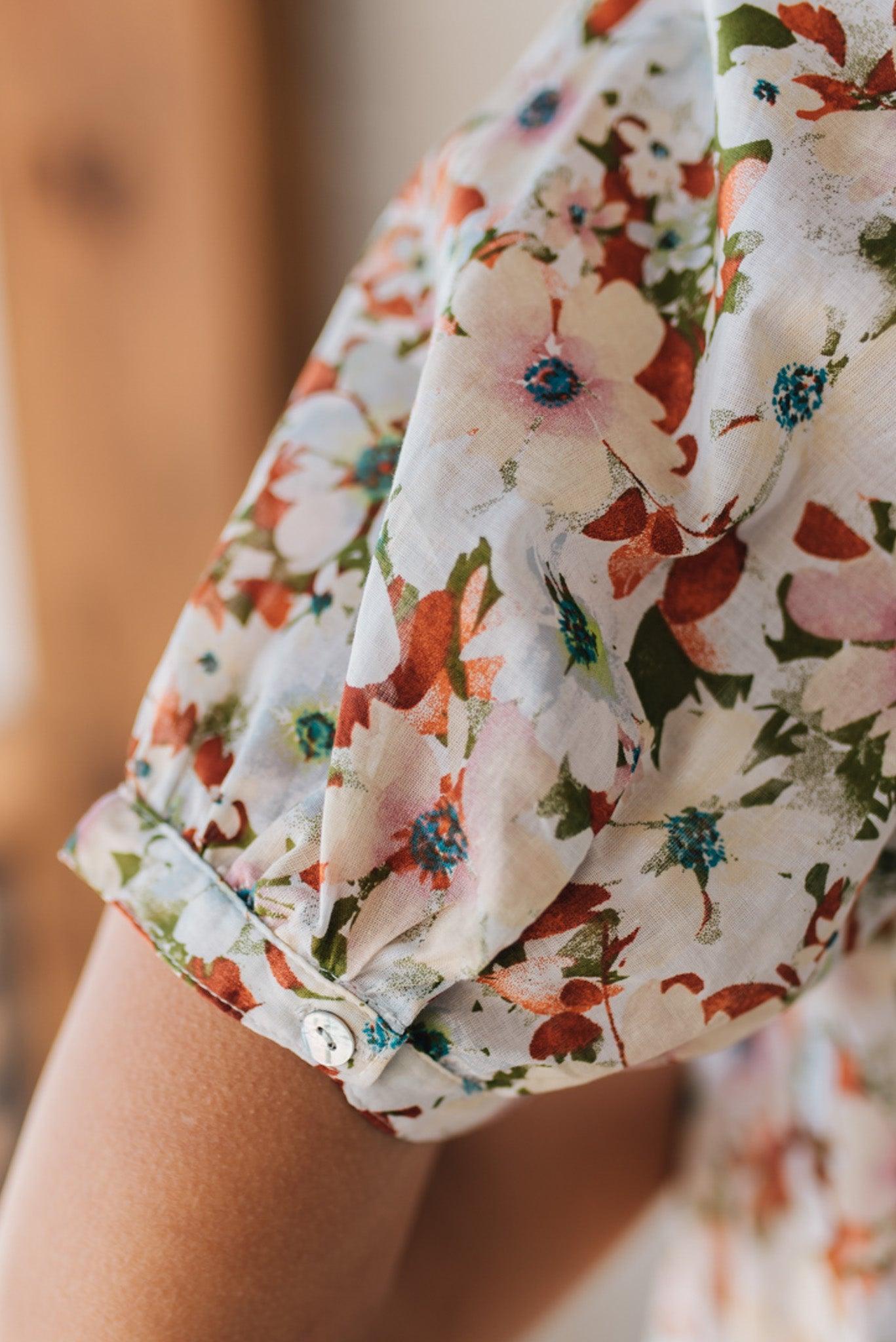 BLONDE WOMAN WEARING A FLORAL BOXY PUFF SLEEVE BUTTON UP TOP