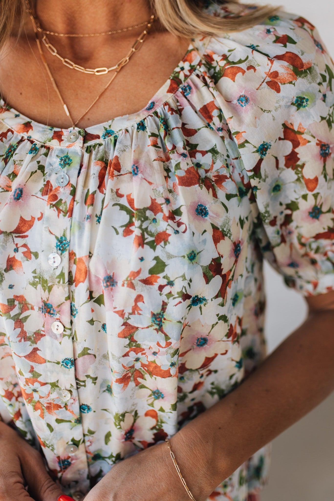BLONDE WOMAN WEARING A FLORAL BOXY PUFF SLEEVE BUTTON UP TOP