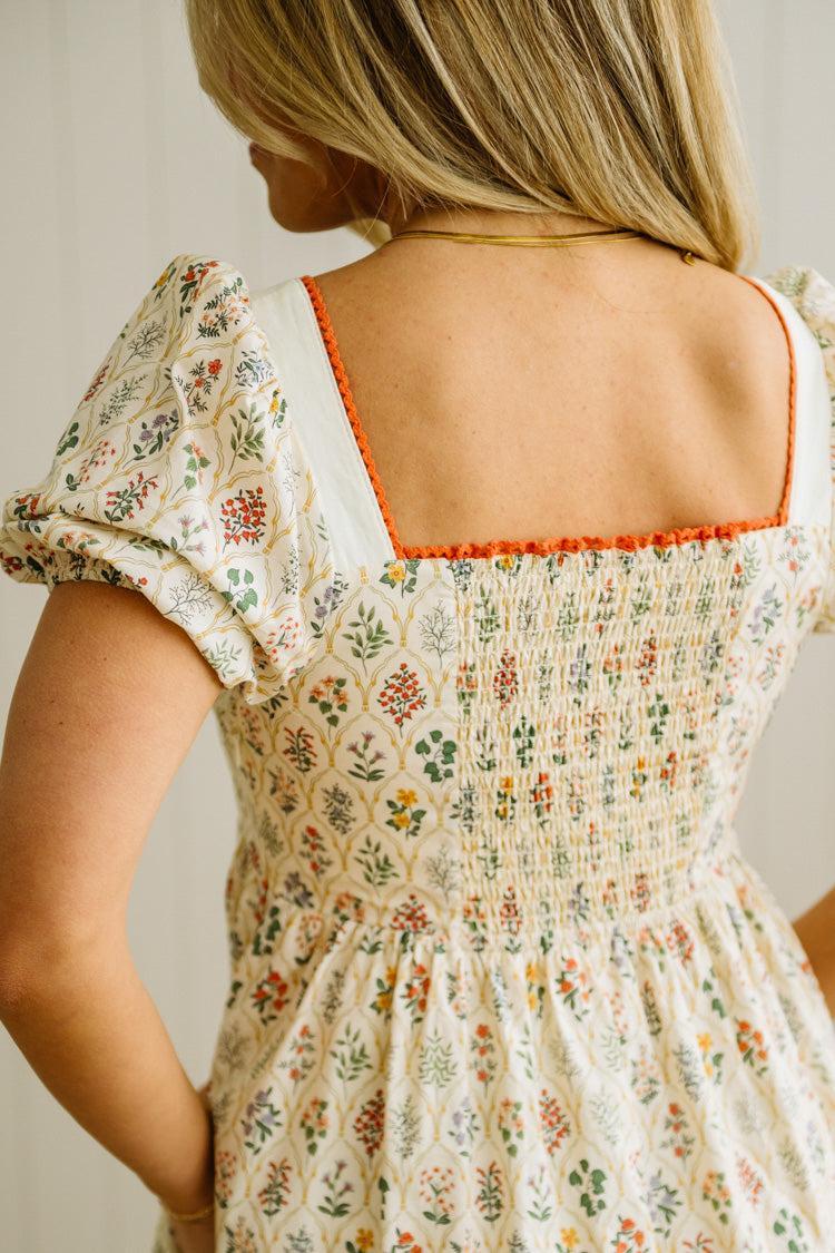 Woman wearing a floral dress with a plain background