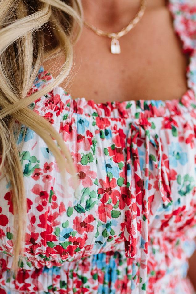 Close-up of a person wearing a colorful floral dress with a necklace.
