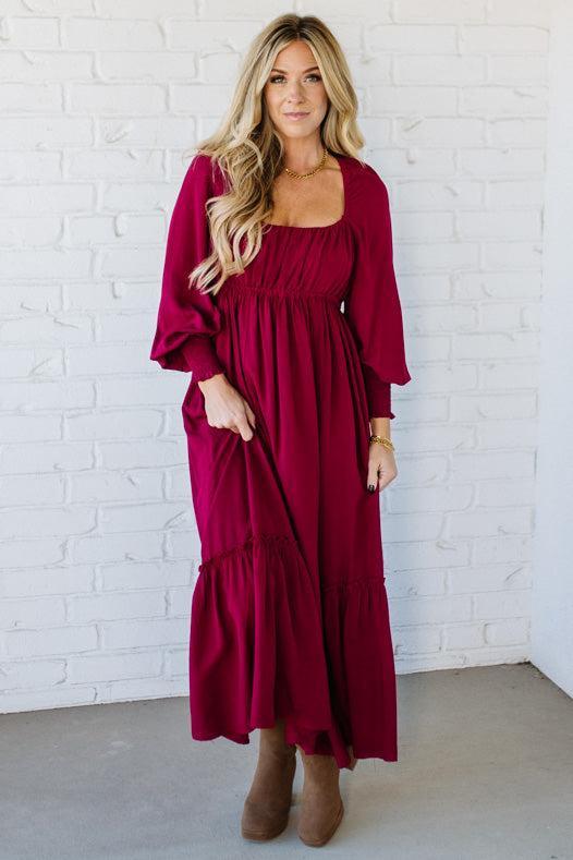 Blonde Woman Wearing a Gathered Long Sleeve Maxi Dress in the color Cherry Merlot.