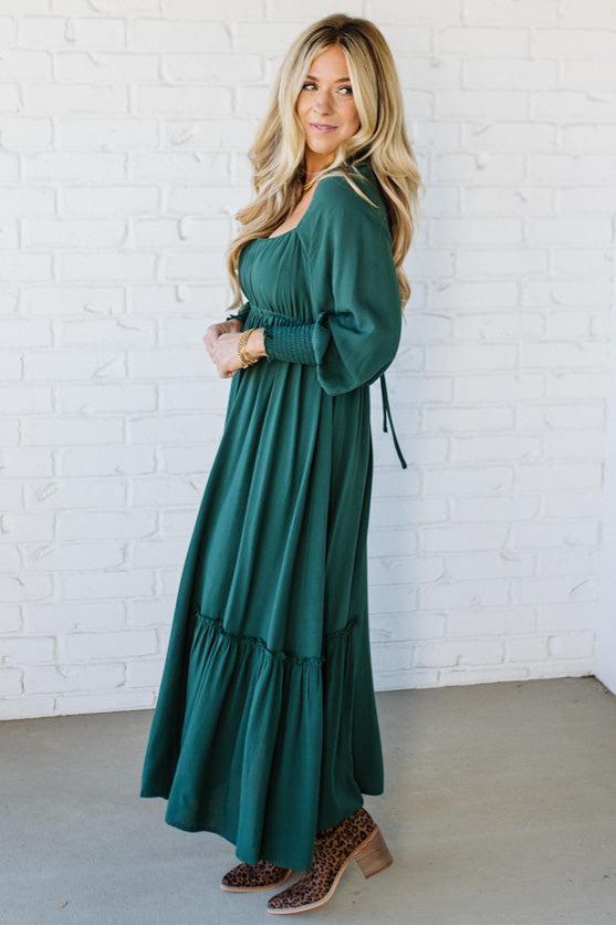 Blonde Woman Wearing a Gathered Long Sleeve Maxi Dress in the color Deep Forest.