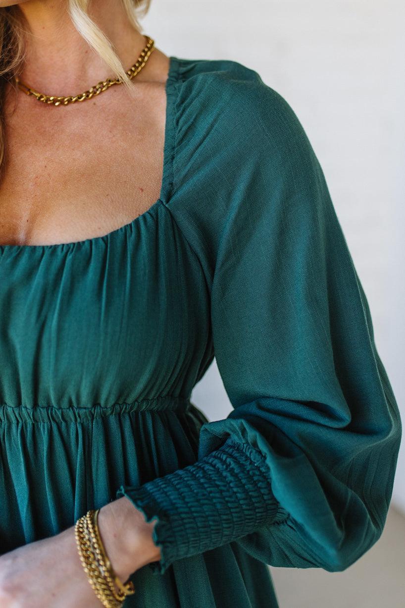 Blonde Woman Wearing a Gathered Long Sleeve Maxi Dress in the color Deep Forest.