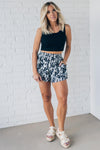 Black and white floral shorts with side pockets, and smocked waistband.
