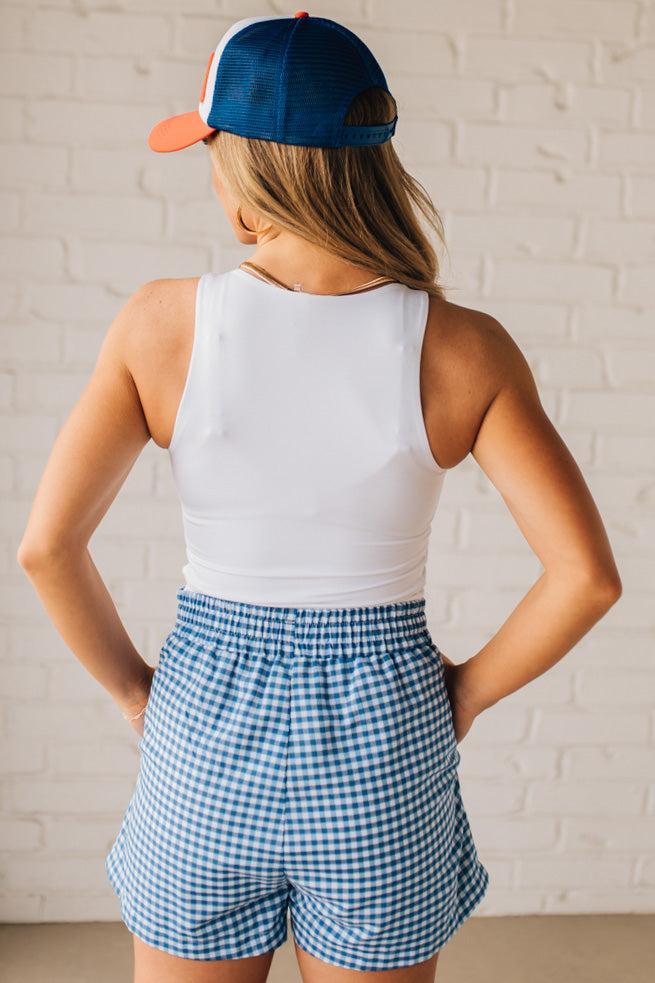 BLONDE WOMAN WEARING GINGHAM CHECK WOVEN BOXER SHORTS WITH SIDE POCKETS.