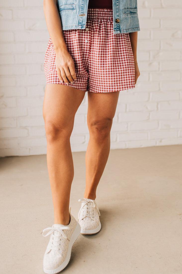 BLONDE WOMAN WEARING GINGHAM CHECK WOVEN BOXER SHORTS WITH SIDE POCKETS.