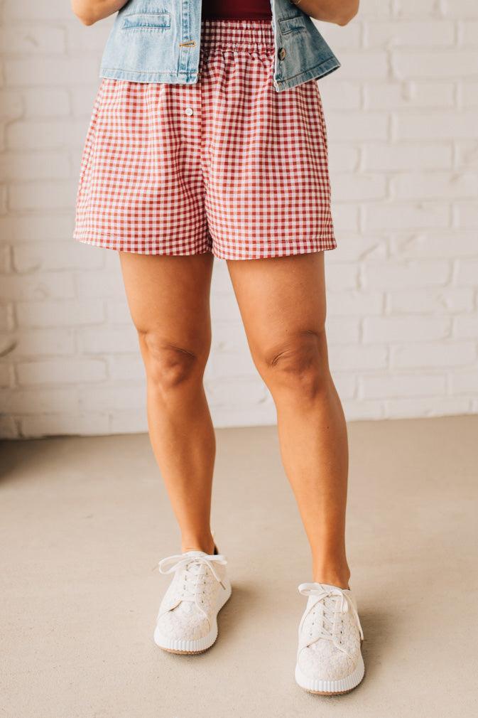 BLONDE WOMAN WEARING GINGHAM CHECK WOVEN BOXER SHORTS WITH SIDE POCKETS.