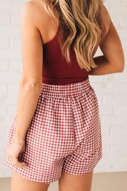 BLONDE WOMAN WEARING GINGHAM CHECK WOVEN BOXER SHORTS WITH SIDE POCKETS.