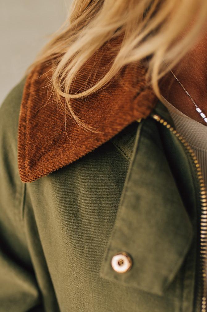 Green jacket with brown collar and gold zipper