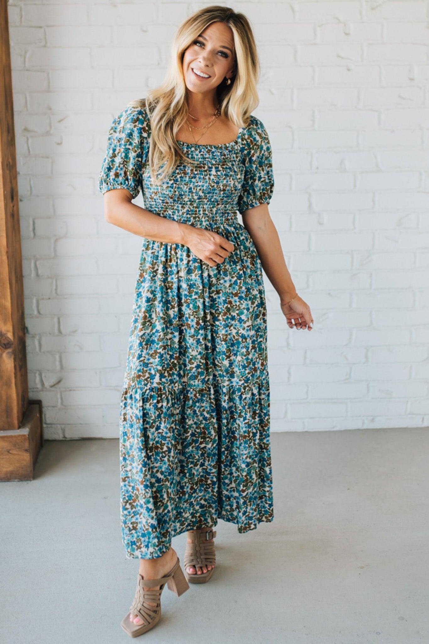Blonde Woman Wearing A Floral Print Smocked Bodice Tiered Midi Dress.