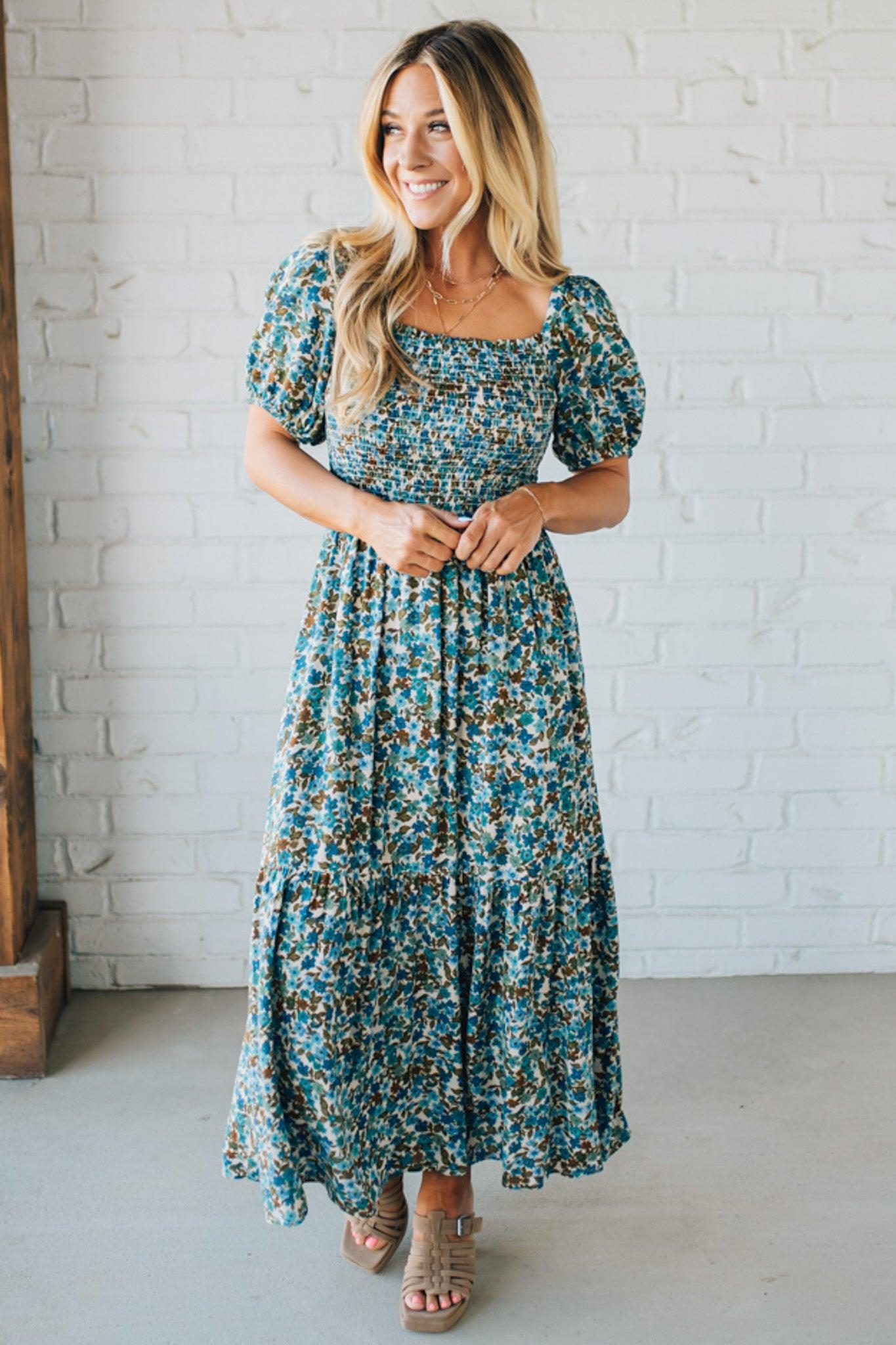 Blonde Woman Wearing A Floral Print Smocked Bodice Tiered Midi Dress.
