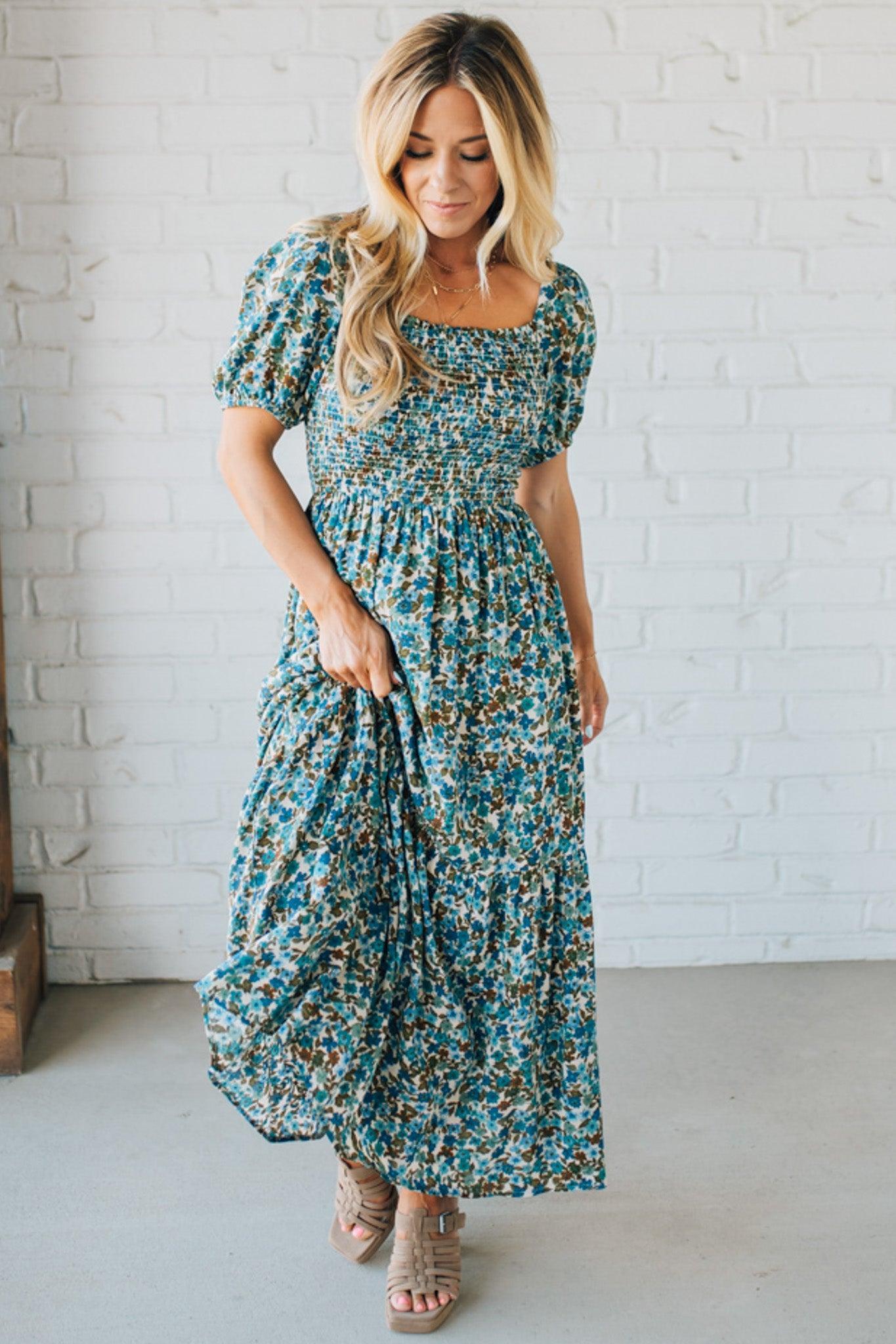 Blonde Woman Wearing A Floral Print Smocked Bodice Tiered Midi Dress.