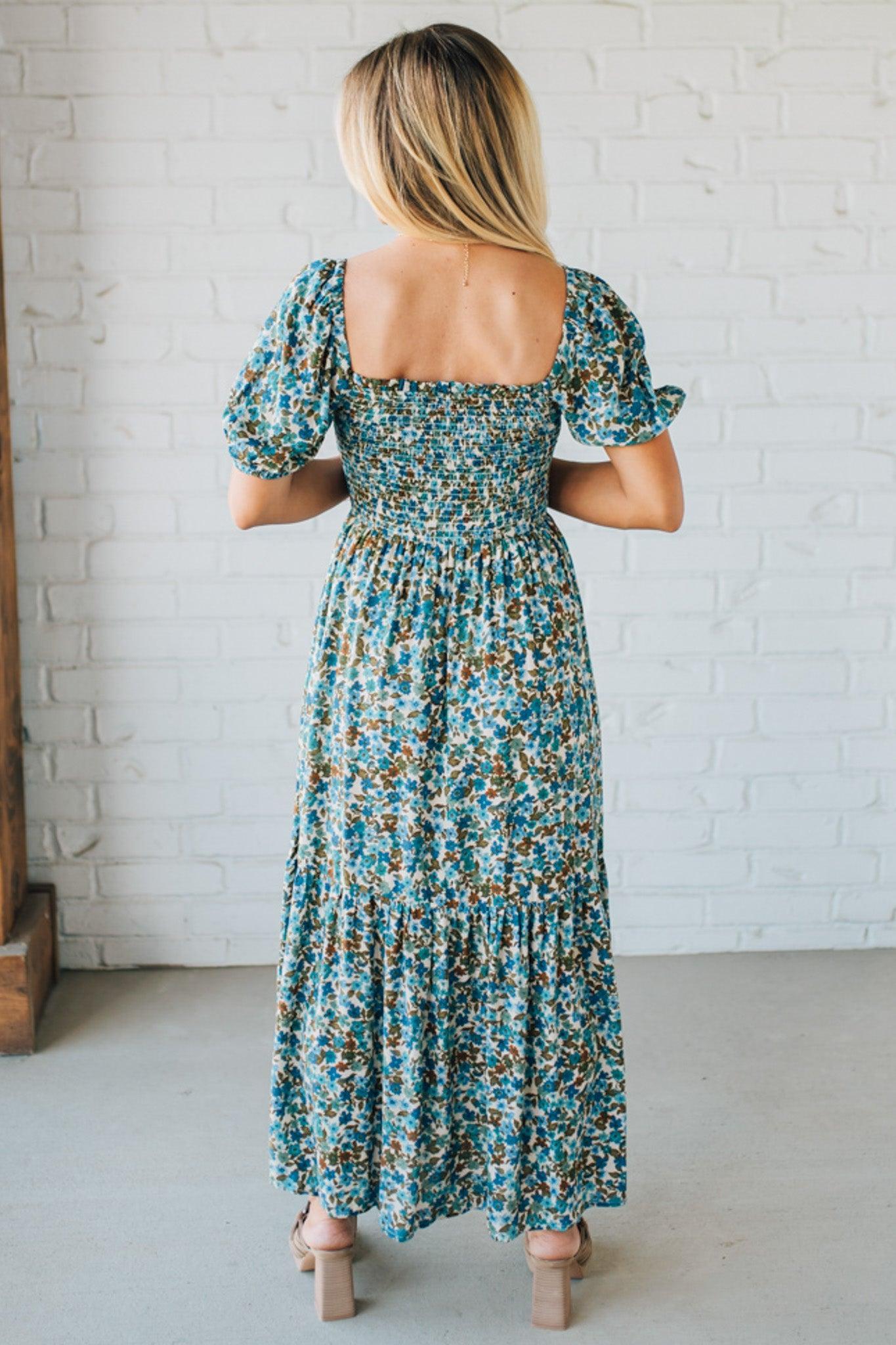 Blonde Woman Wearing A Floral Print Smocked Bodice Tiered Midi Dress.
