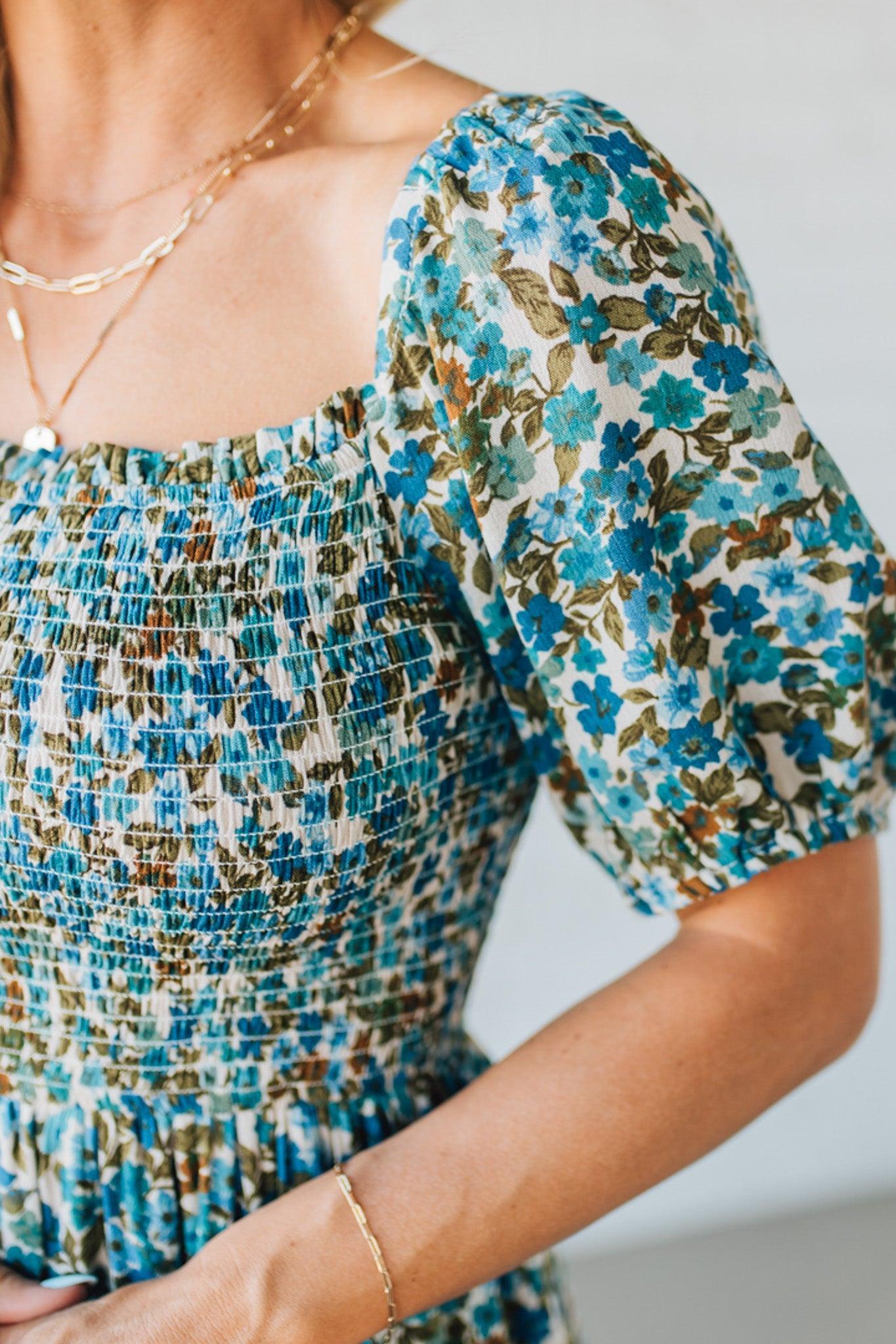 Blonde Woman Wearing A Floral Print Smocked Bodice Tiered Midi Dress.