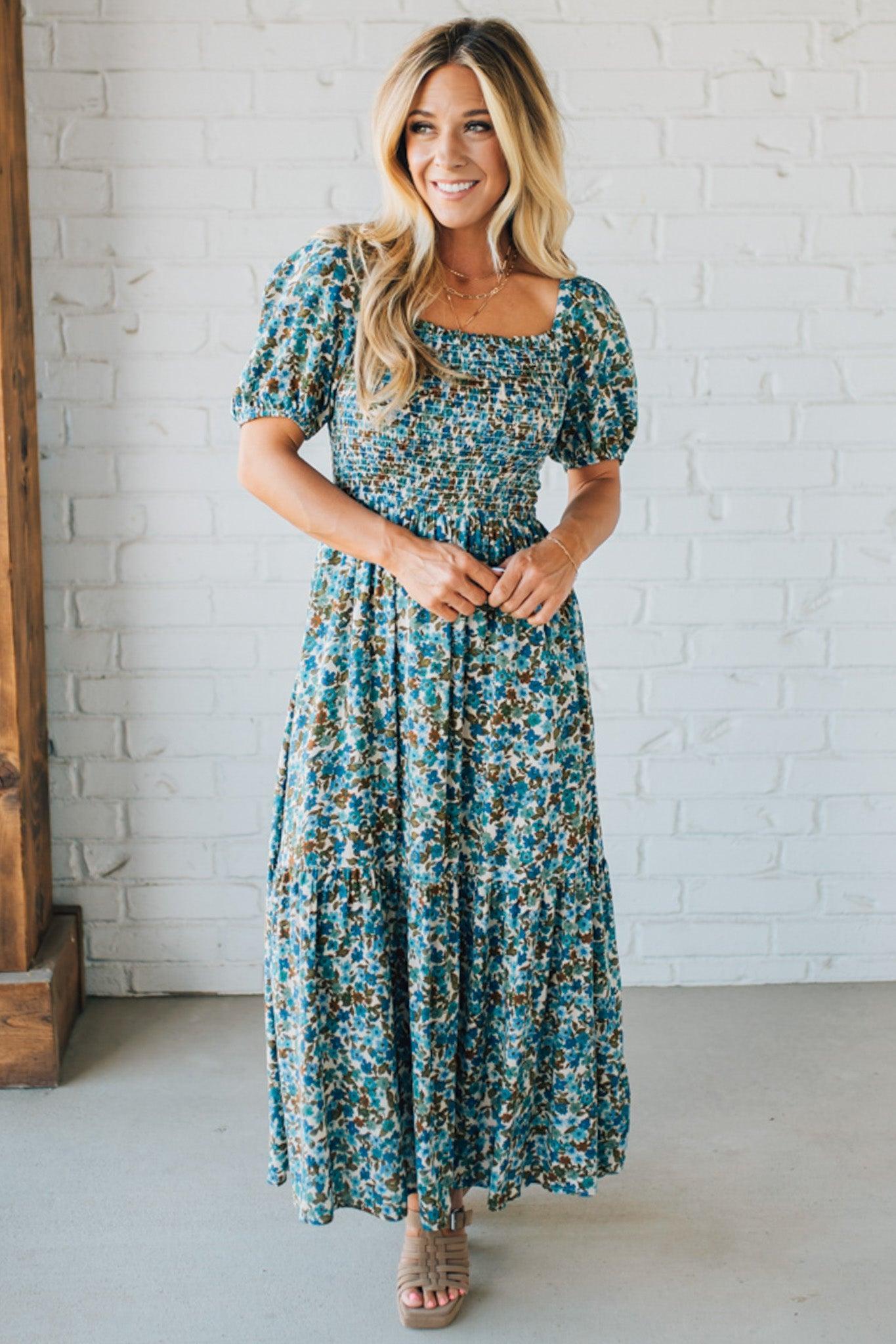 Blonde Woman Wearing A Floral Print Smocked Bodice Tiered Midi Dress.