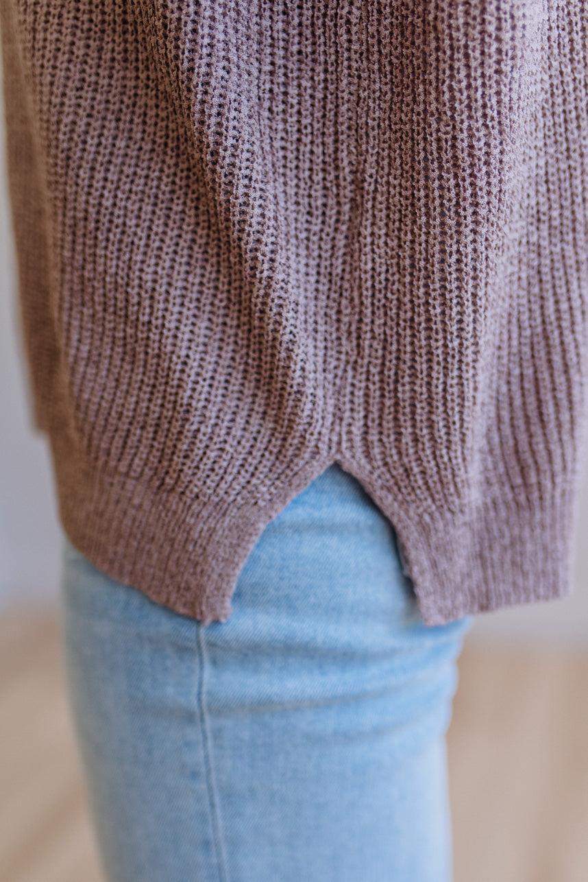 Blonde woman wearing a short sleeve v-neck ribbed texture sweater with center patch accent in mocha.