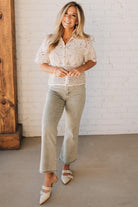 Blonde woman wearing light olive acid wash crop jeans with frayed ankle.