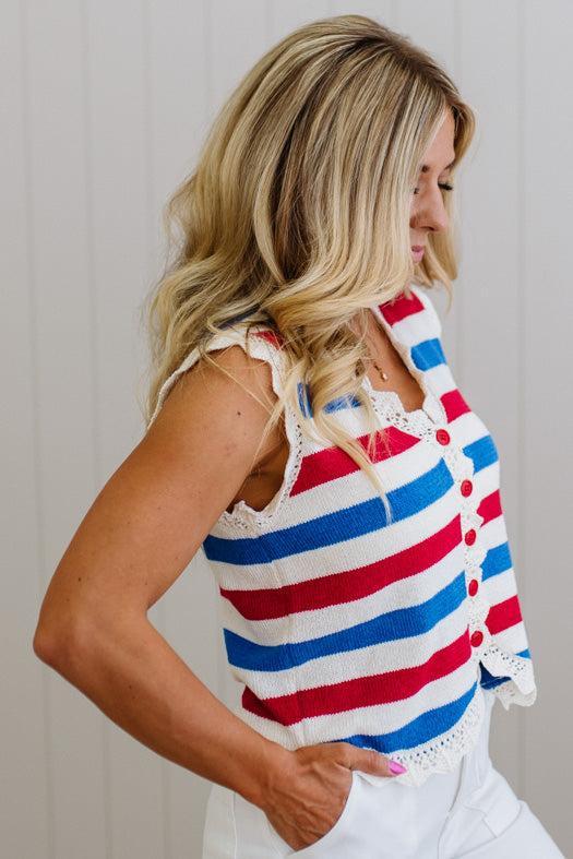 Woman wearing a red, white, and blue striped top with buttons.