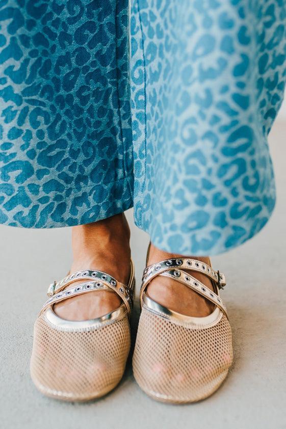 Women's gold flat sandals with a mesh outer, and double grommet lined fauze leather straps.
