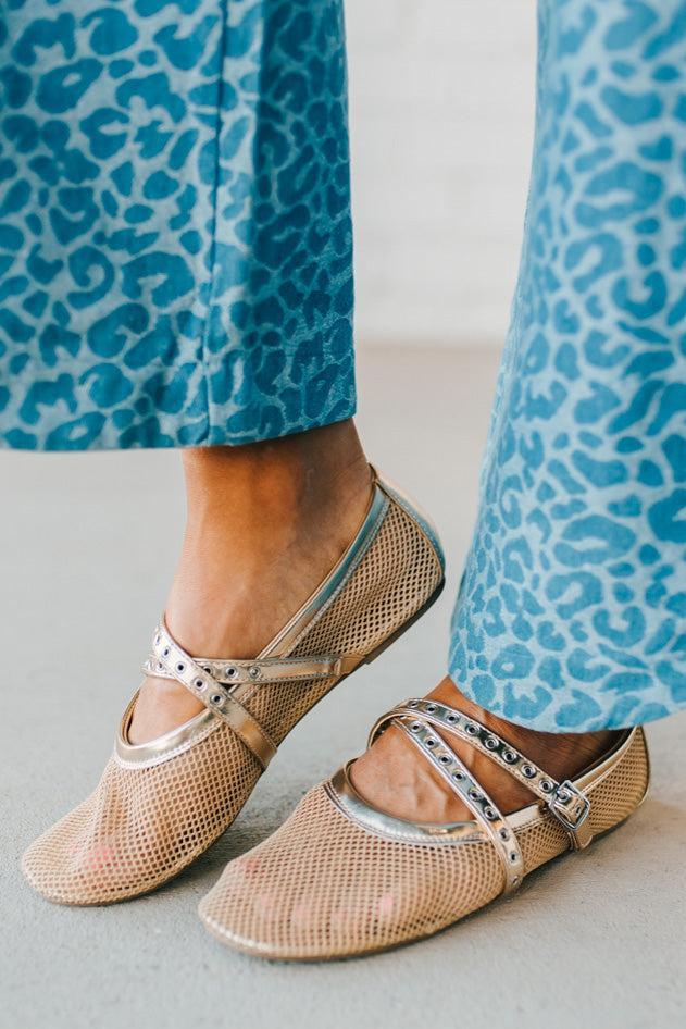 Women's gold flat sandals with a mesh outer, and double grommet lined fauze leather straps.