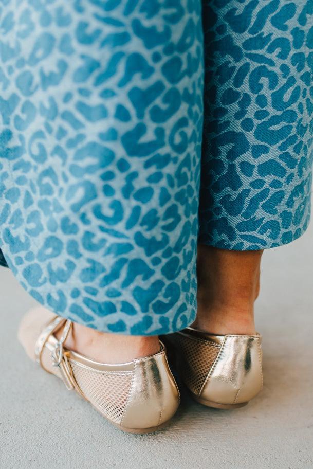 Women's gold flat sandals with a mesh outer, and double grommet lined fauze leather straps.