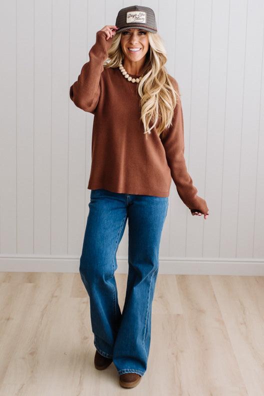 Blonde woman in a plaid hat wearing a solid waffle texture sweater with drop shoulder seams and crewneck.