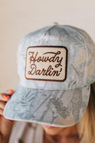 Blonde woman wearing a Howdy Darlin' Embroidery Patch Camo Trucker Hat.