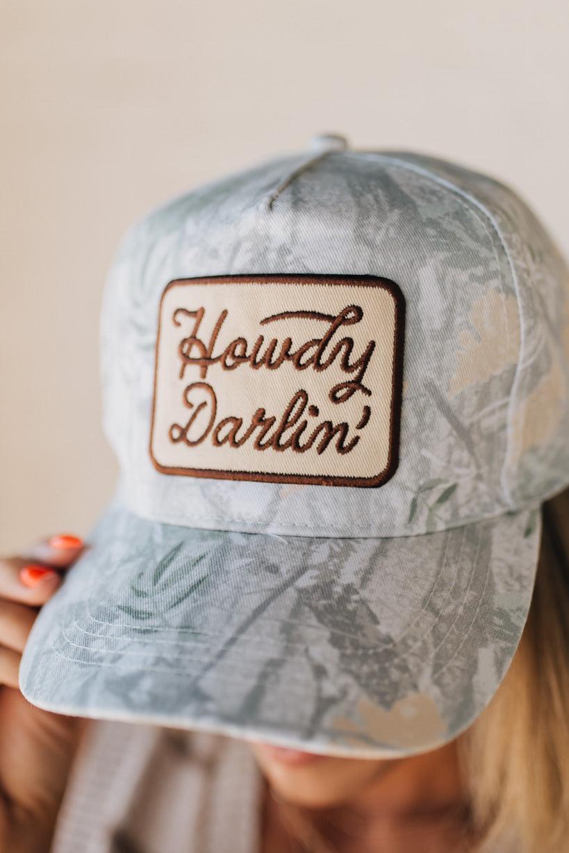 Blonde woman wearing a Howdy Darlin' Embroidery Patch Camo Trucker Hat.