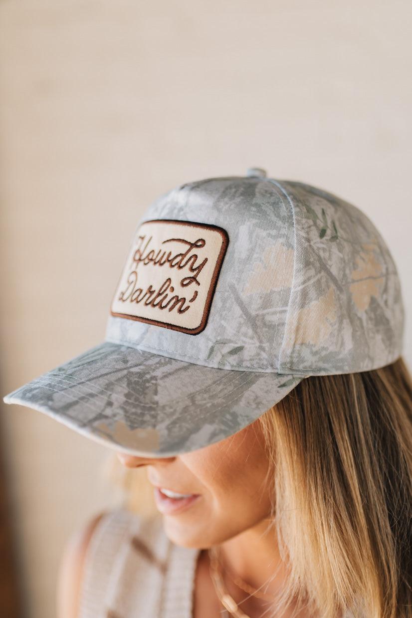 Blonde woman wearing a Howdy Darlin' Embroidery Patch Camo Trucker Hat.