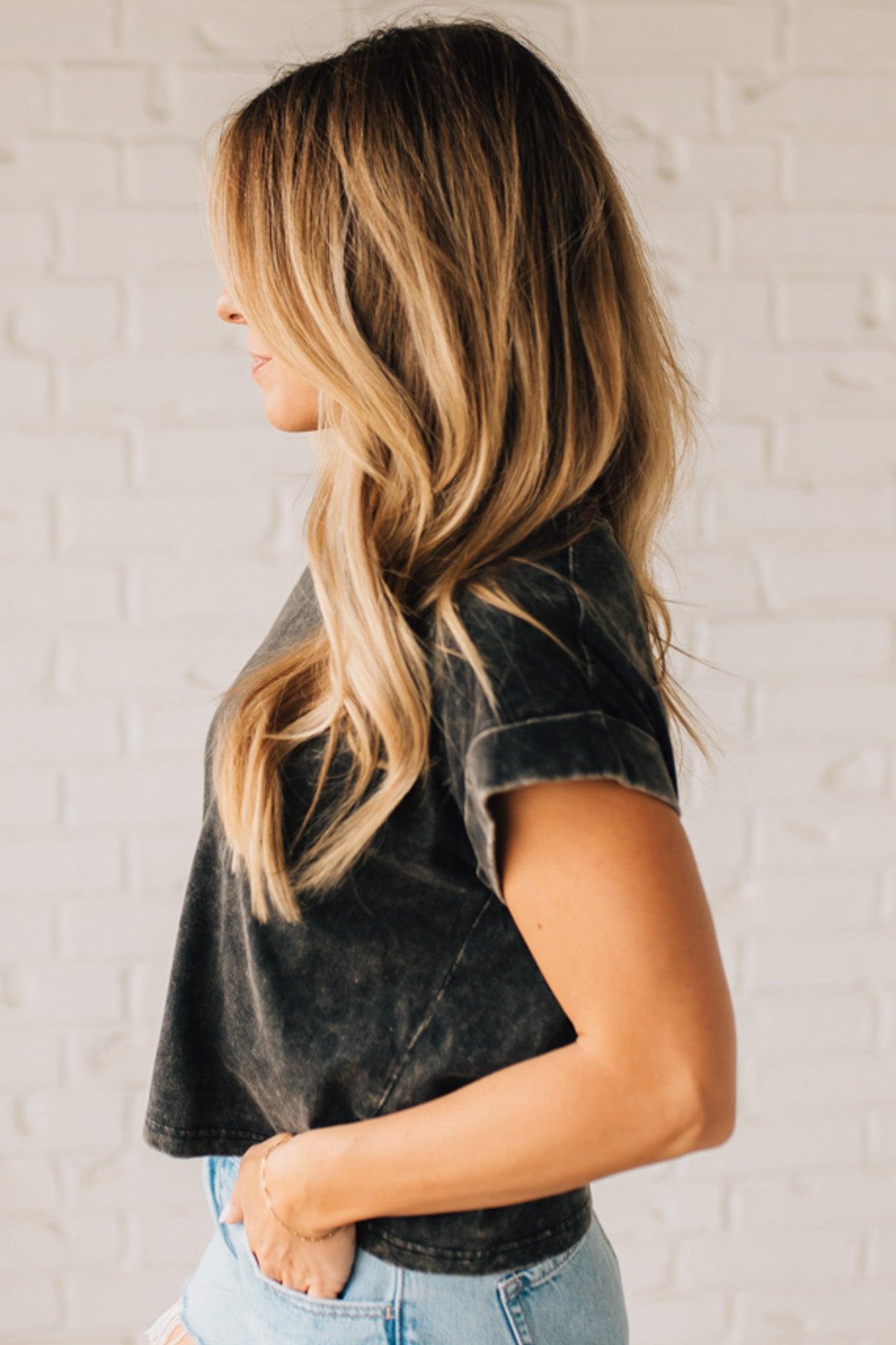 BLONDE WOMAN WEARING A MINERAL WASHED COTTON CUFFED SHORT SLEEVE TOP.