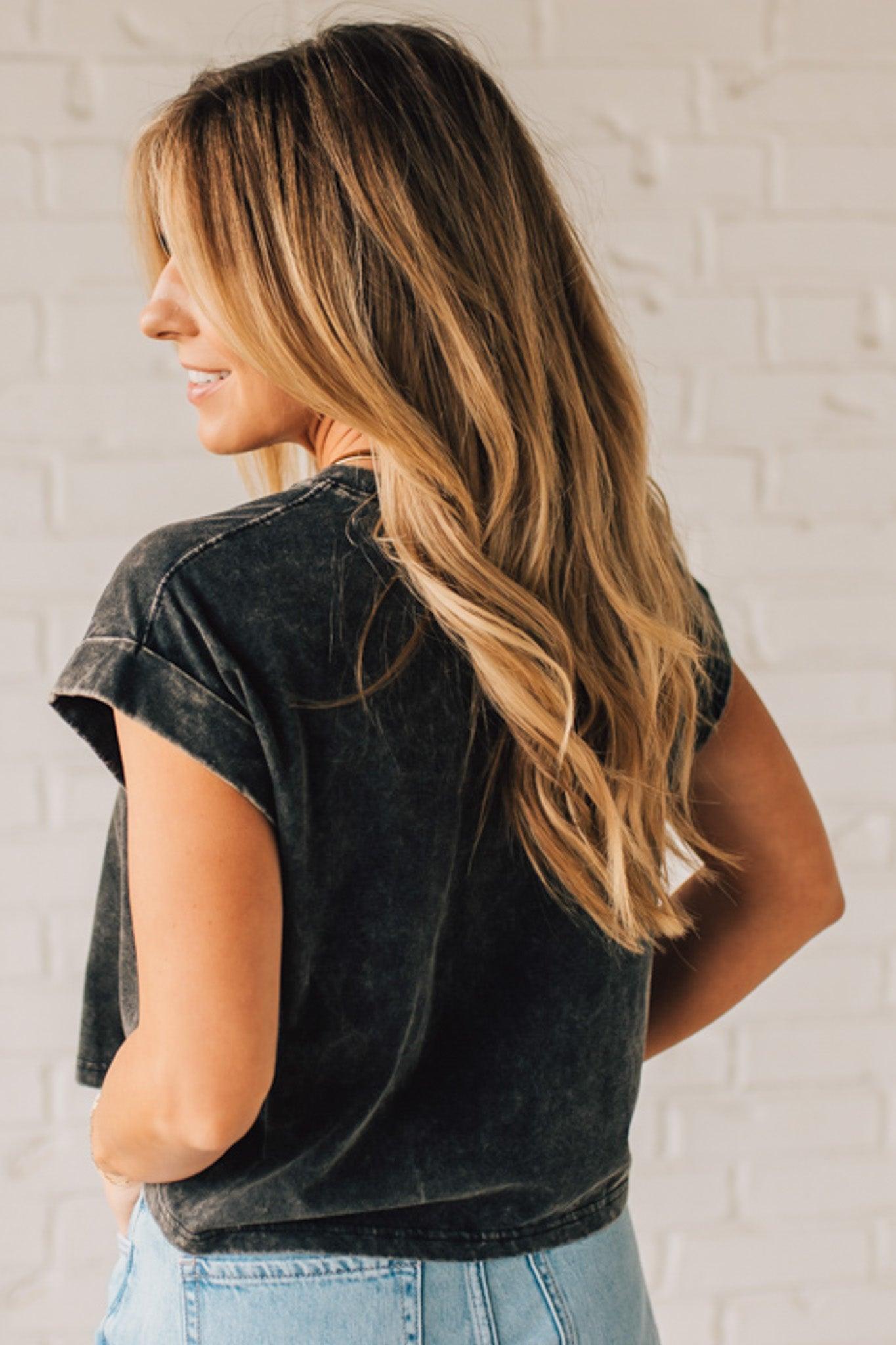 BLONDE WOMAN WEARING A MINERAL WASHED COTTON CUFFED SHORT SLEEVE TOP.