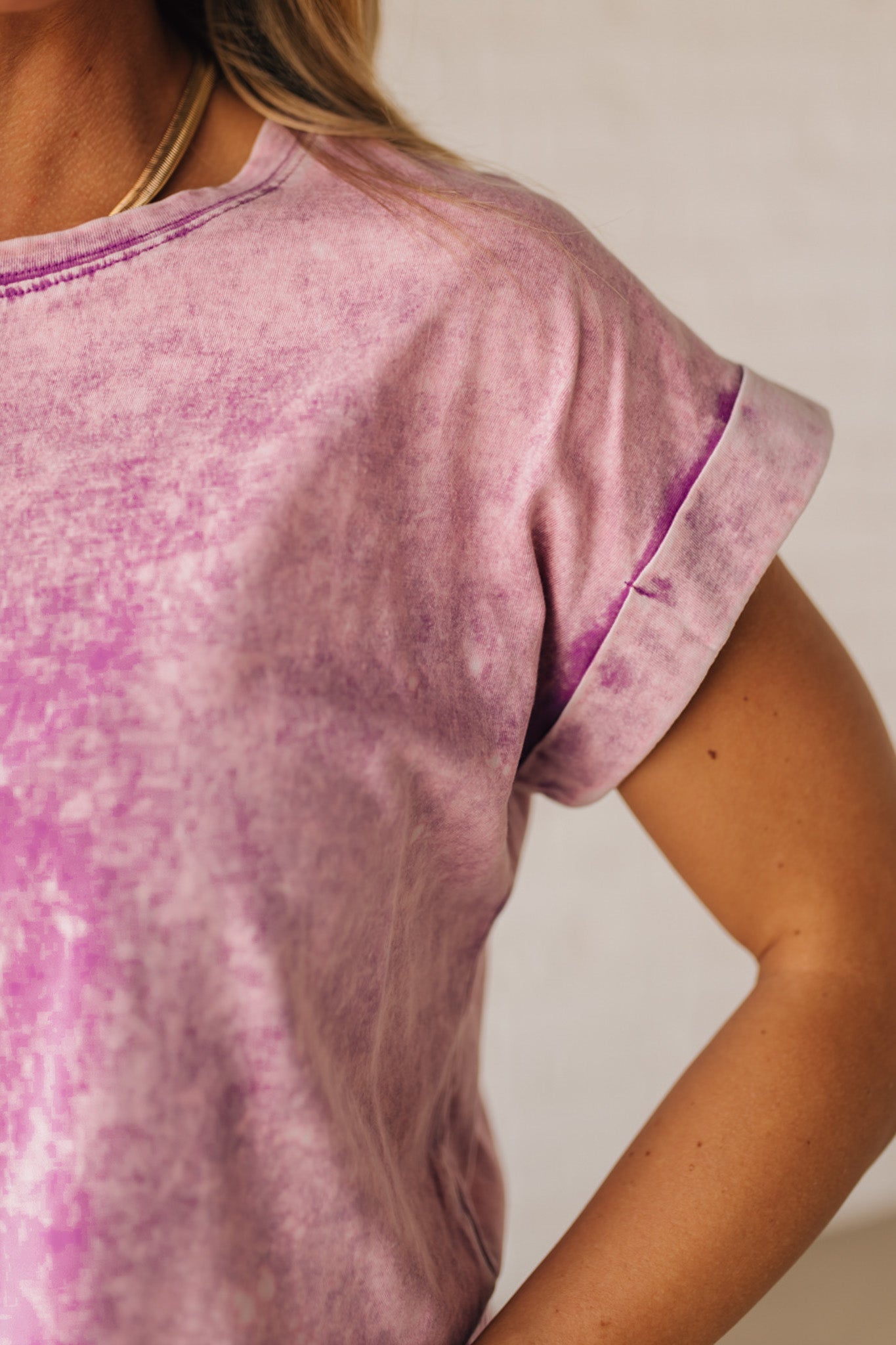 BLONDE WOMAN WEARING A MINERAL WASHED COTTON CUFFED SHORT SLEEVE TOP.