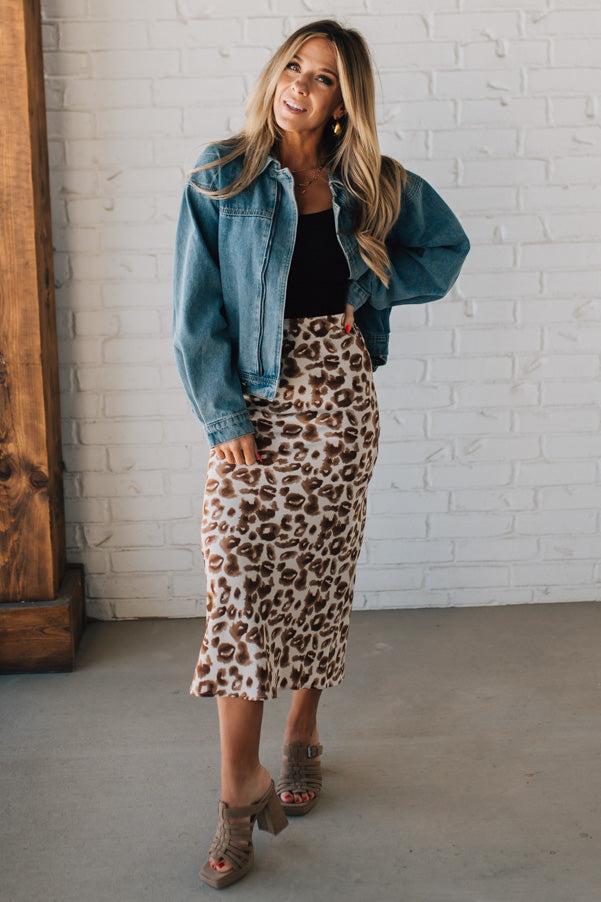 WOMAN WEARING AN ANIMAL PRINT BIAS CUT SATIN MIDI SKIRT.