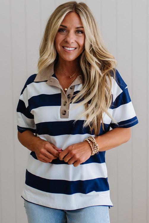 Woman wearing a blue and white striped shirt with a neutral background